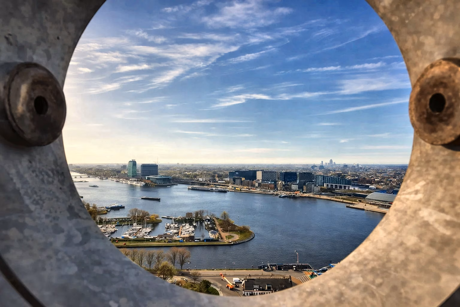 A’DAM Lookout shows a wide river surrounded by modern buildings and boats at the marina