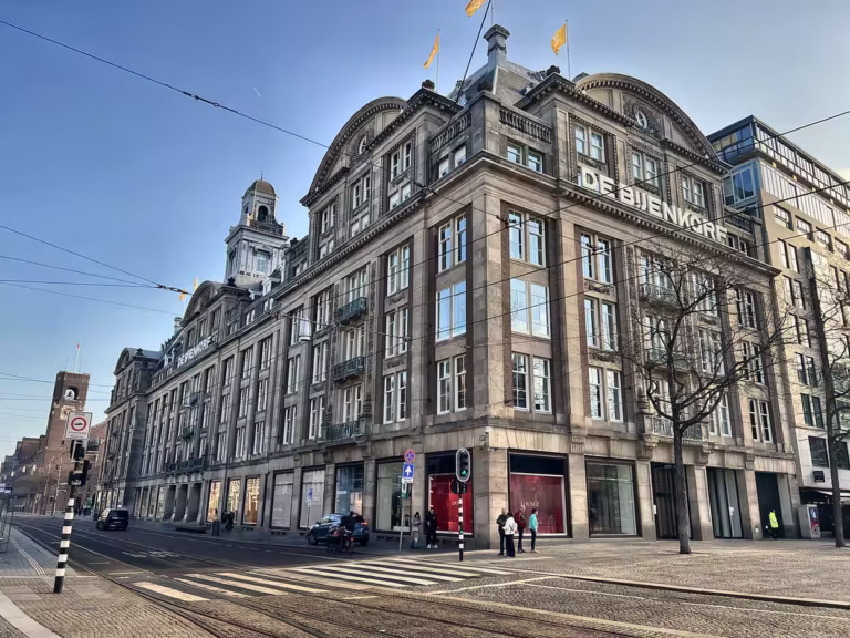 The impressive facade of Bijenkorf Amsterdam features large windows and grand architecture capturing its historical elegance