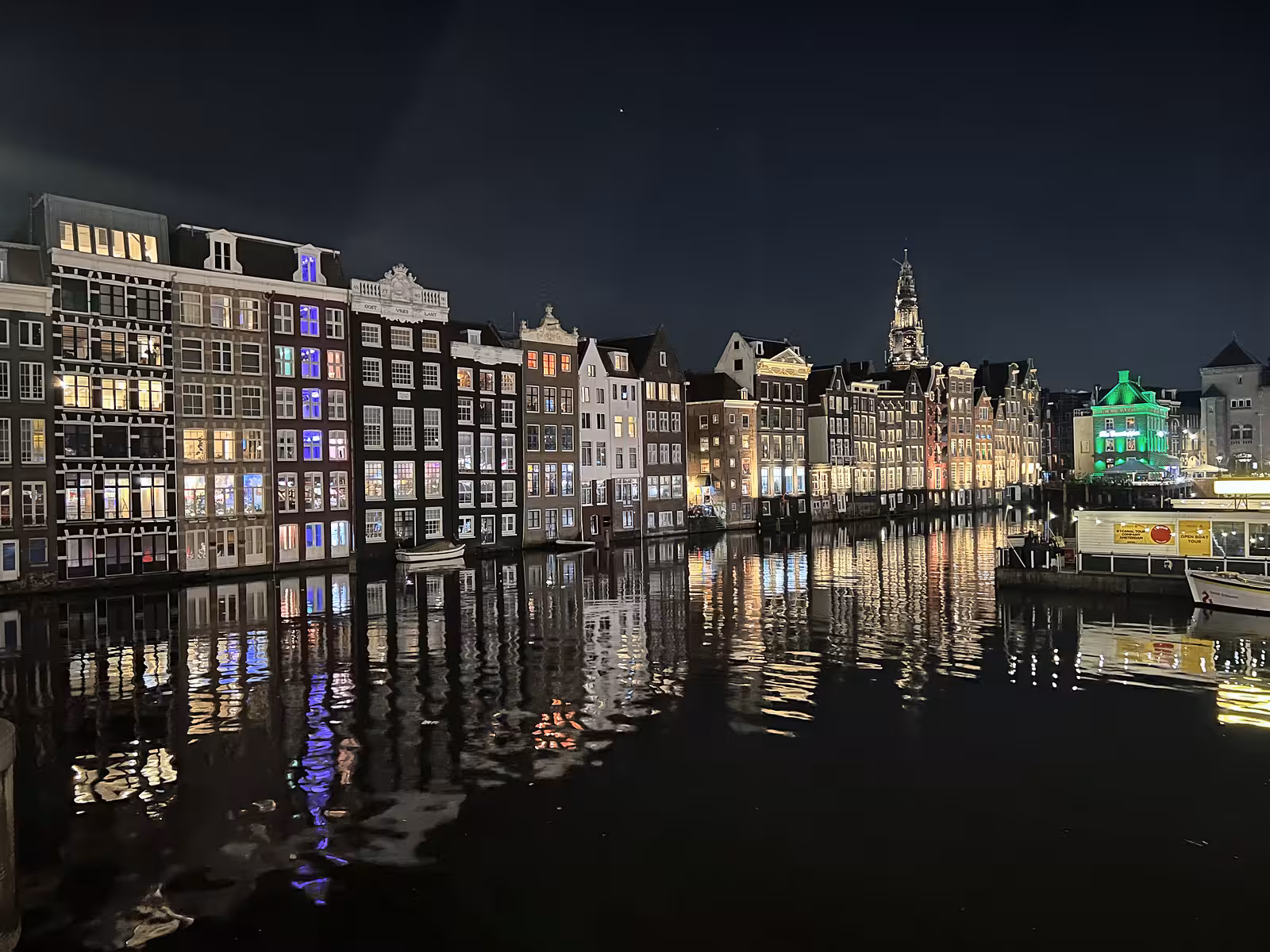 The illuminated buildings along the Canals Amsterdam reflect beautifully on the still water creating a serene night scene