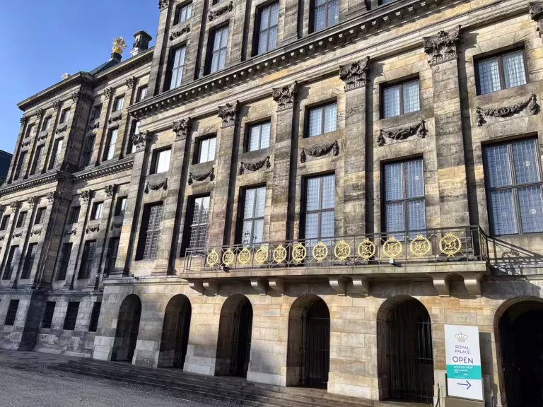 The elegant architecture of the royal palace in amsterdam is prominently featured near Dam square with intricate details
