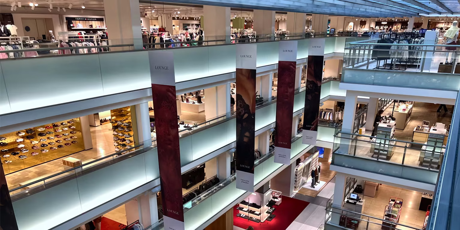 A modern shopping mall (Bijenkorf) with multiple floors showcasing various stores where you can discover unique products and brands.
