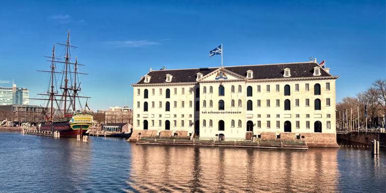 The historic building - Maritime Museum along the waterfront invites visitors to discover its rich maritime history in Amsterdam.