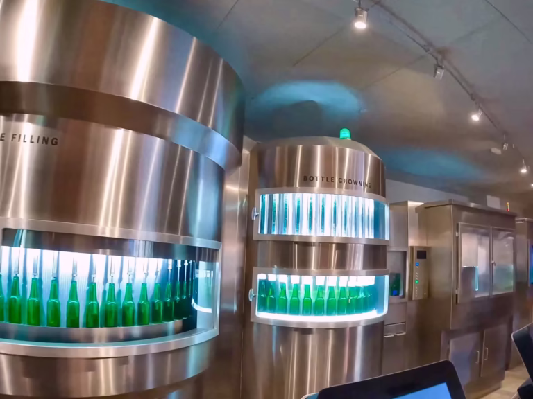 The Heineken experience showcases modern bottling machines with filled green bottles illustrating beer production technology