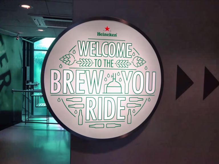 The Heineken experience sign welcomes visitors to the brew you ride attraction featuring playful design elements