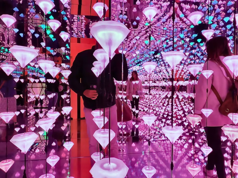 Visitors interact with vibrant light installations at the Moco museum creating a dynamic and immersive experience
