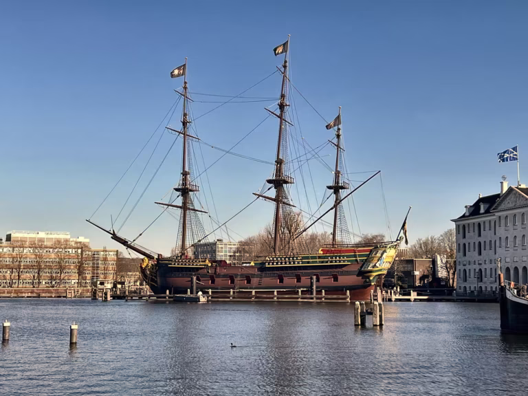 A historic ship moored near the National Maritime Museum showcases maritime heritage against a clear blue sky - Museums & Art