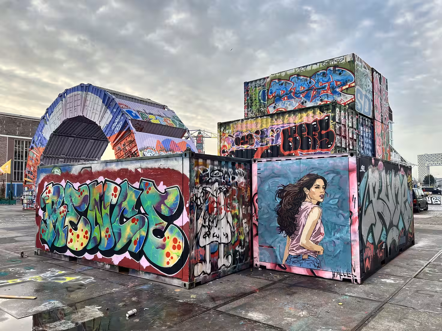 Colorful graffiti covers large shipping containers at NDSM Wharf showcasing various artistic styles and designs in urban art