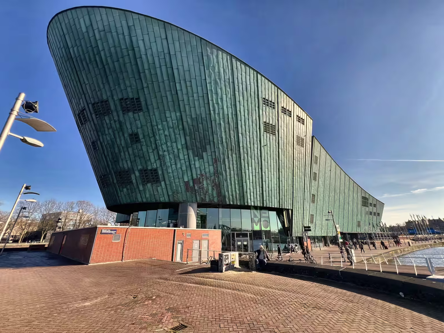 The NEMO Science Museum features a striking green facade with an innovative architectural design that attracts visitors daily