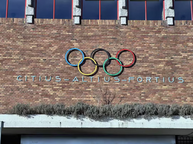 Olympic rings and motto on the brick wall