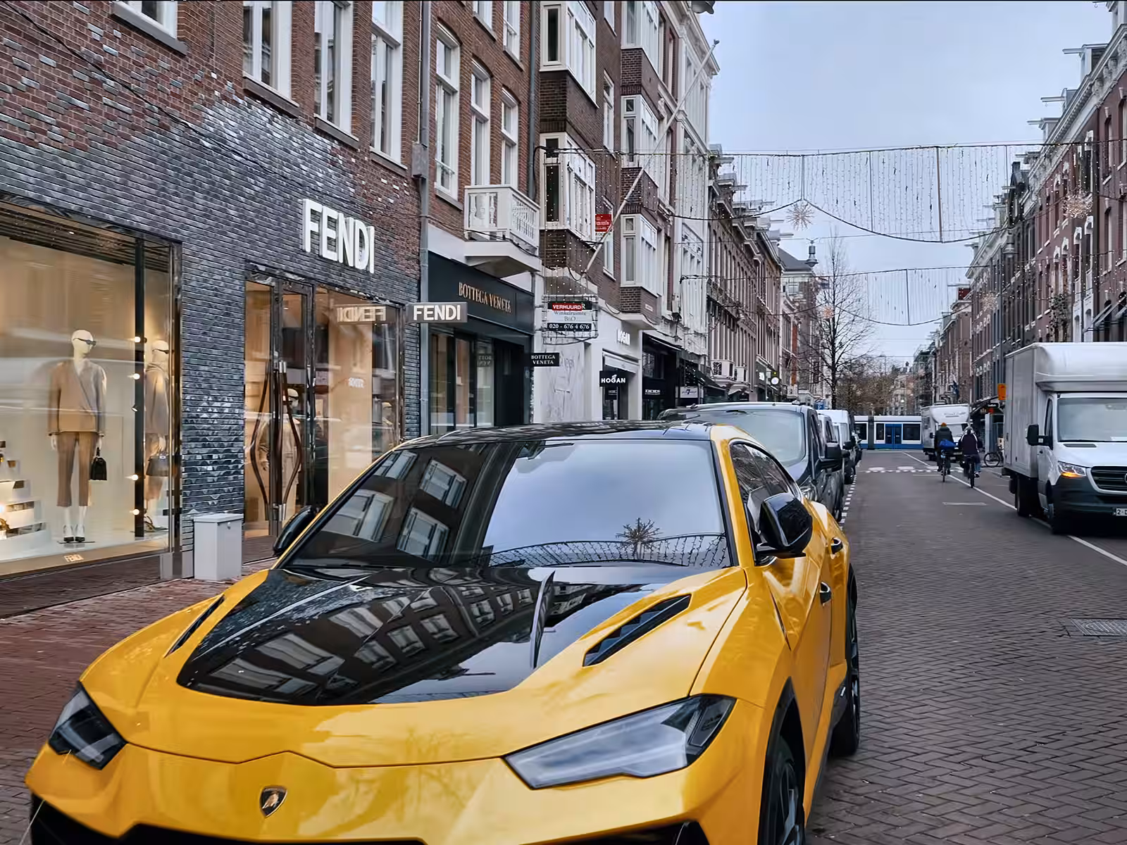 The vibrant PC Hoofdstraat features a striking yellow lamborghini parked near luxury boutiques showcasing elegant designs